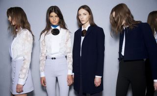 4 Models posing wearing white and navy blue skirts, blouses, trousers, jacket and coats