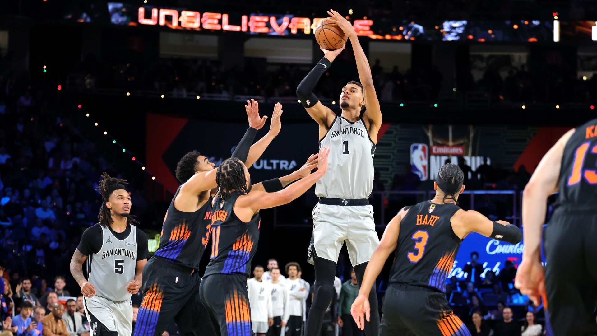 Victor Wembanyama of the San Antonio Spurs shoots against Jalen Brunson and Karl-Anthony Towns of the New York Knicks