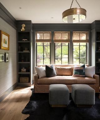 home office with dark gray trim, large windows and beige sofa