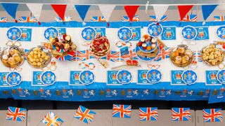 jubilee decorations along a trestle table filled with food for for a street party