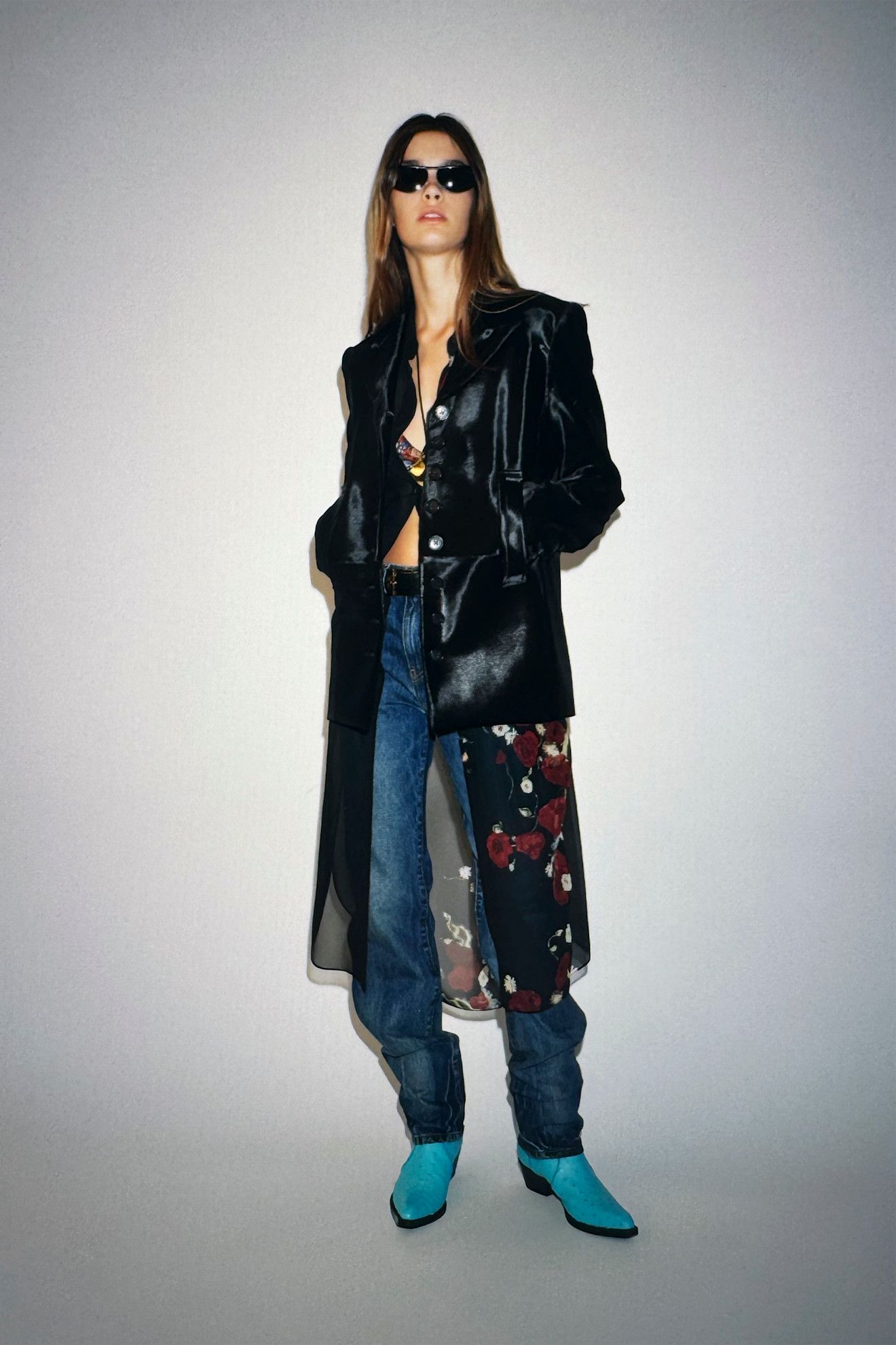 A Khaite model wearing a black calf hair blazer, floral dress, and jeans from the Resort 26 collection.