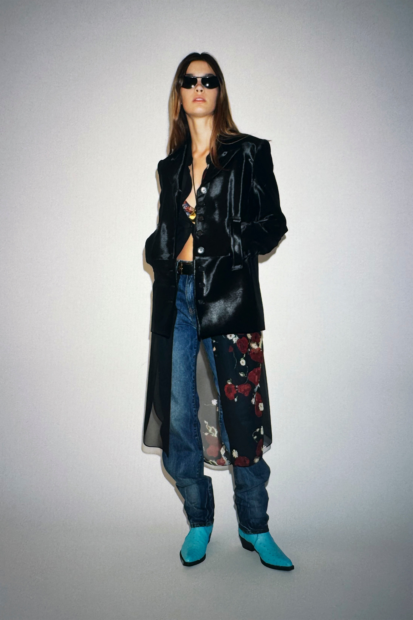 A Khaite model wearing a black calf hair blazer, floral dress, and jeans from the Resort 26 collection.