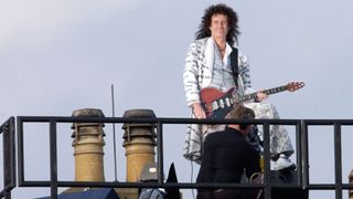 Brian May performing on the roof of Buckingham Palace