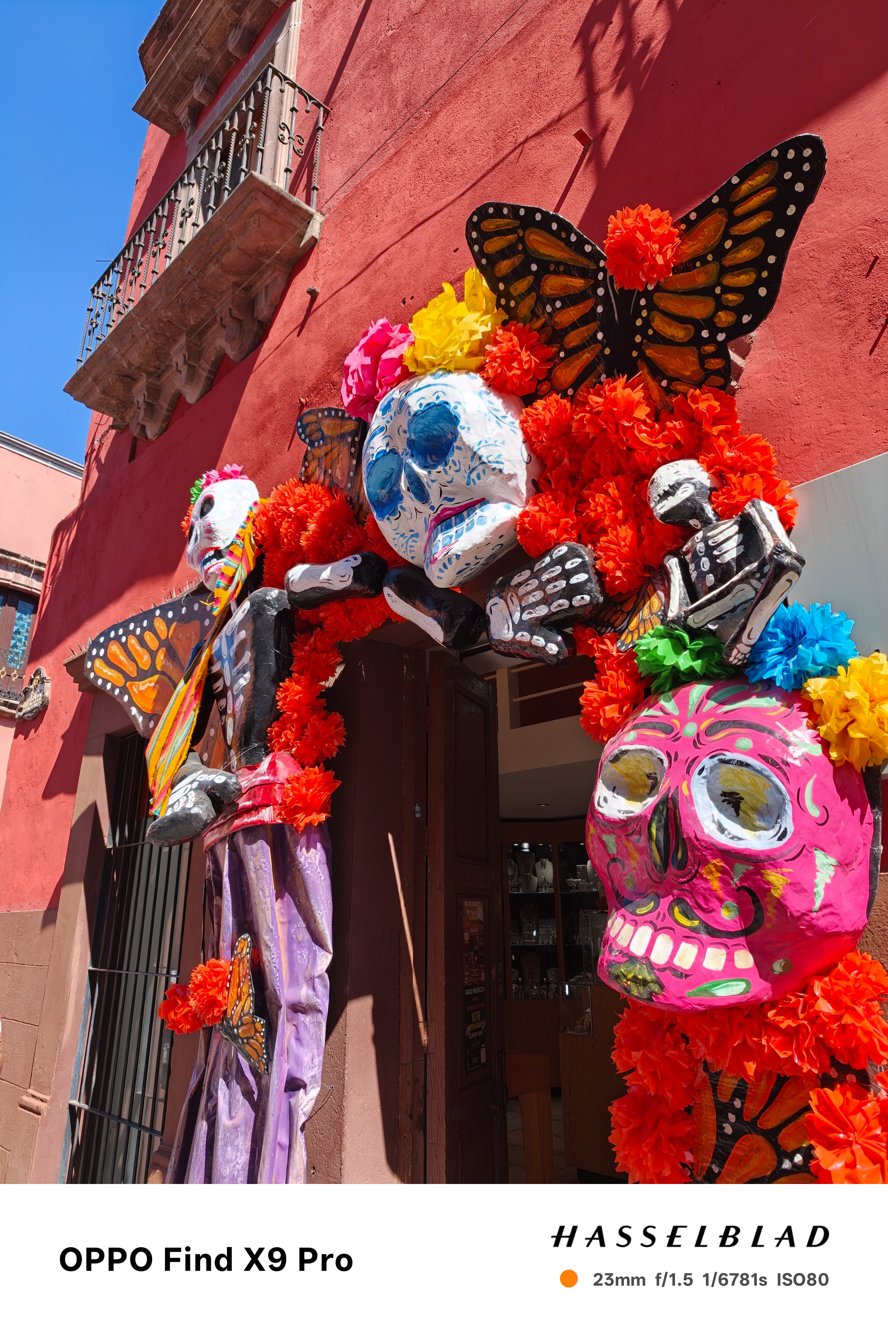 Colourful day of the dead characters adorn the top of a doorway of a shop in Mexico