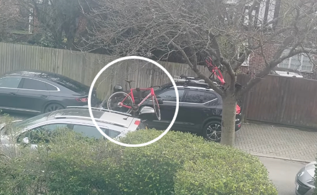 Thieves stealing a bike from a car roof rack