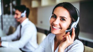Lady wearing telephone headset in contact centre