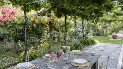 Open concept-garden broken up by an outdoor dining space
