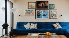 Cream living room with gallery wall and blue Togo couch