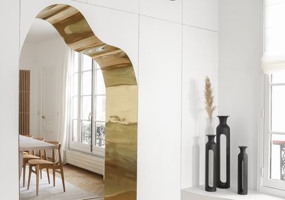 gold edged curved doorway leading into white dining room