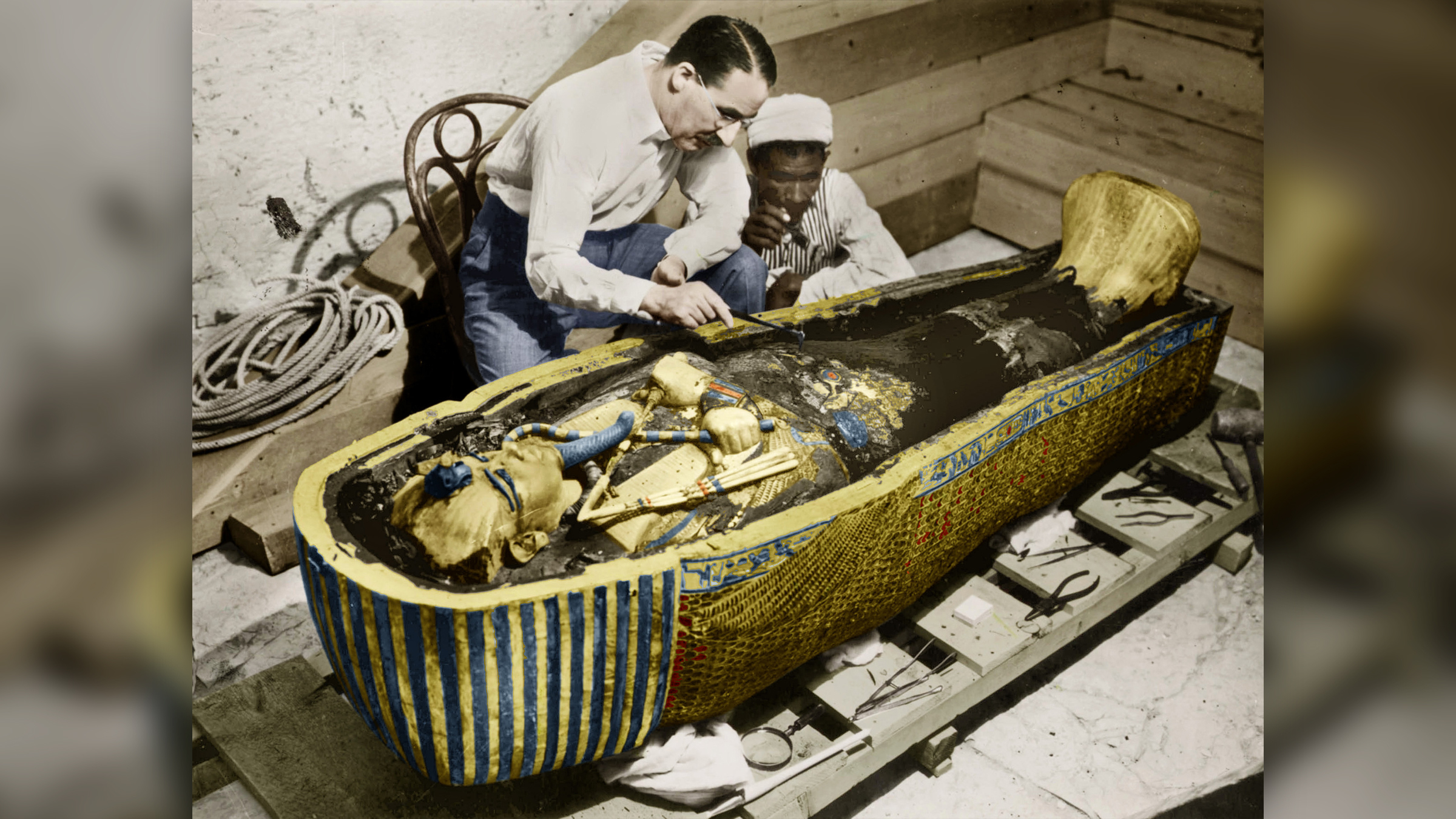 In this colorized photo, English Egyptologist Howard Carter (1873-1939) and a colleague look at the golden sarcophagus of Tutankhamen in Egypt in the early 1920s.