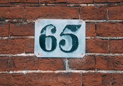 metal number 65 on a brick wall