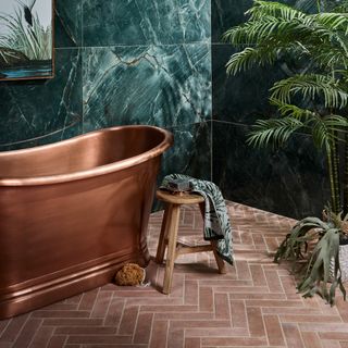 terracotta herringbone bathroom floor with copper bath