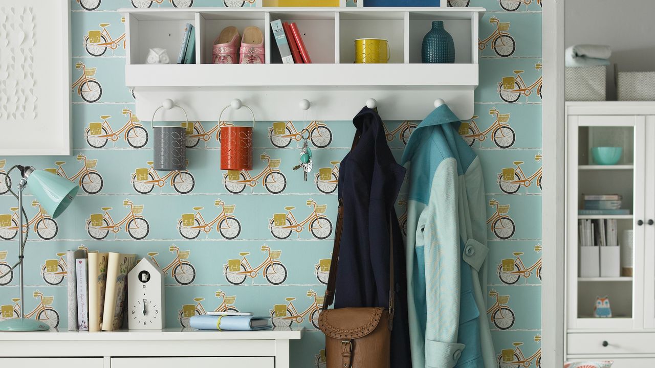 A hallway with a bicycle wallpaper and coat hooks