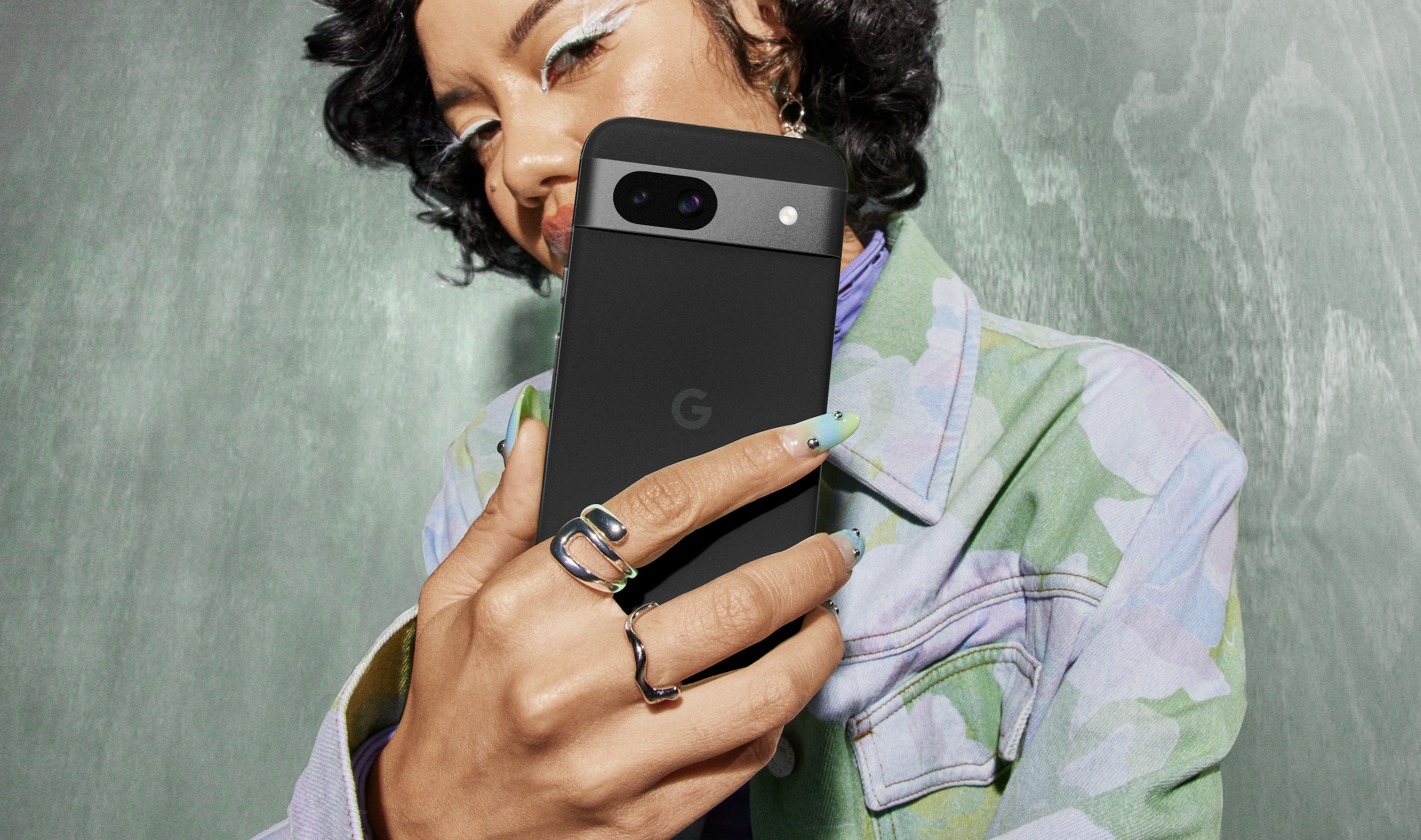 Una mujer sujetando el Google Pixel 8a en color Obsidiana