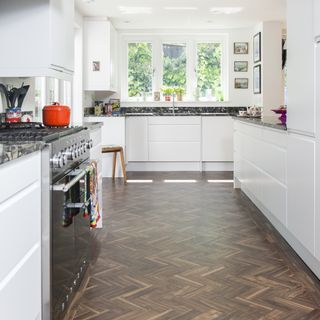 White kitchen with dark parquet flooring