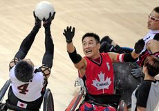 Canada's Ian Chan (R) vies for the ball with Japan's Shinichi Shimakawa (L) in their mixed wheelchair rugby game at the 2008 Beijing Paralympic Games on September 12, 2008 at the USTB Gymnasi