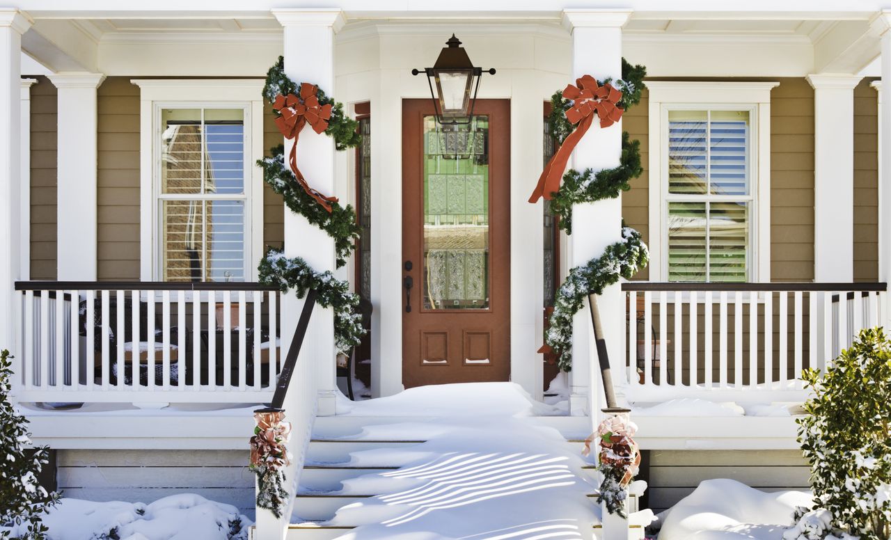 Snowy front porch decorated for Christmas