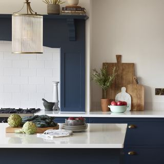 blue kitchen with white tile splashback and upstand