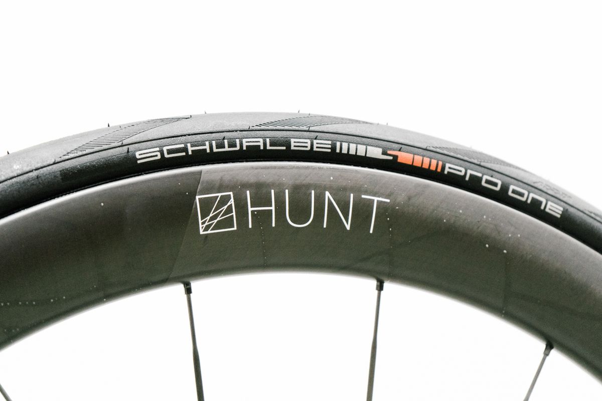 An aero road wheel stands against a white wall