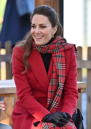 Kate Middleton in a red coat and tartan scarf