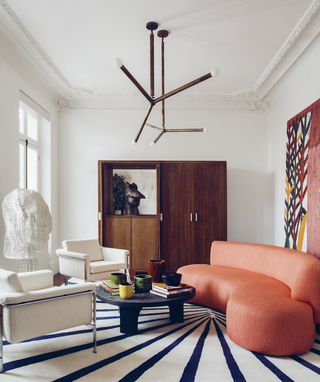 A living room with a large, curving seater and two armchairs