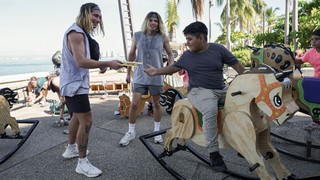 Twins Bailey Smith and Anthony Smith pass a note to a boy on a rocking horse in "The Amazing Race" season 36