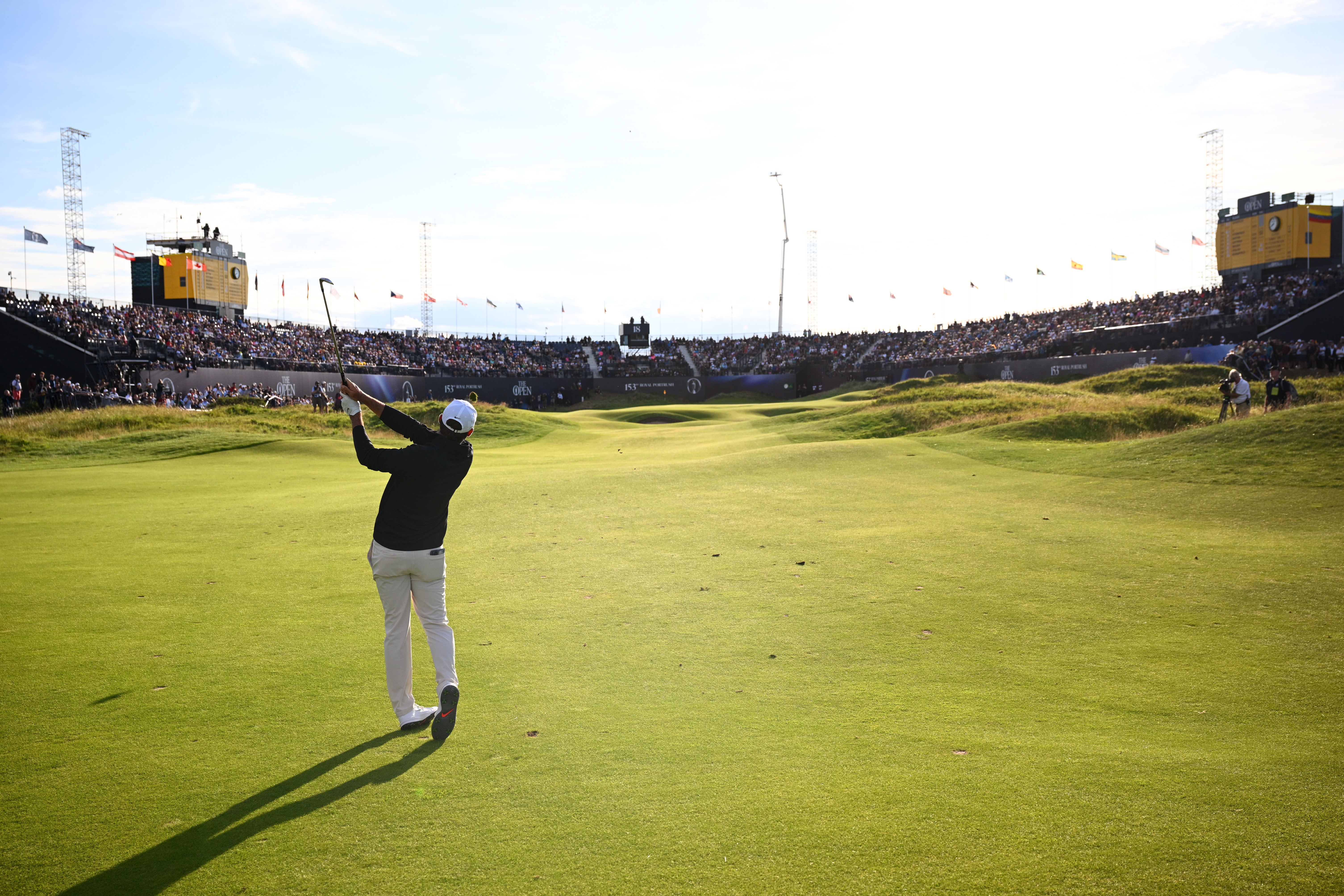 Scottie Scheffler hits an iron shot into the 18th green