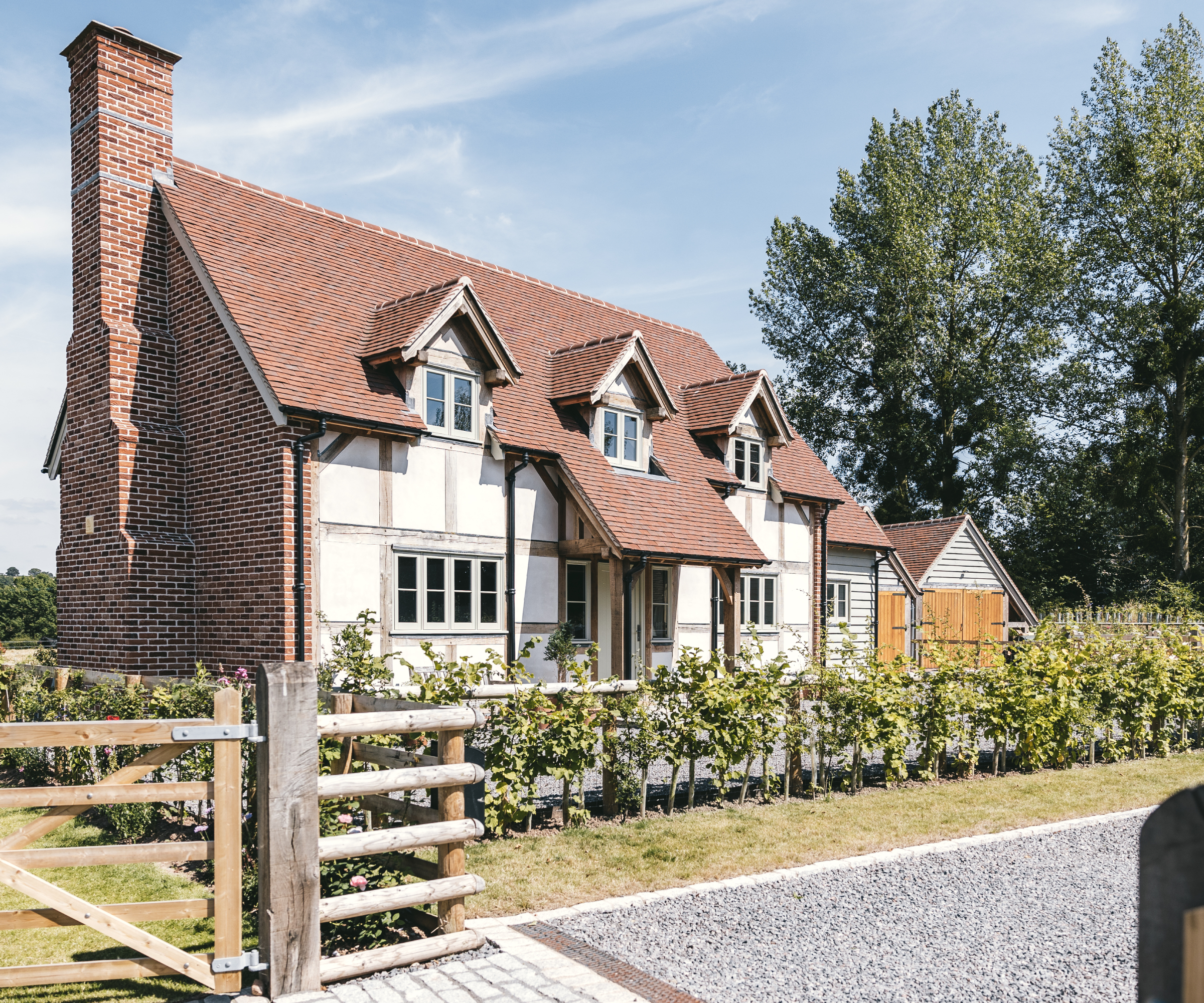 tiled roof extending from main pitched roof over oak framed canopy porch with simple oak pillars and framework
