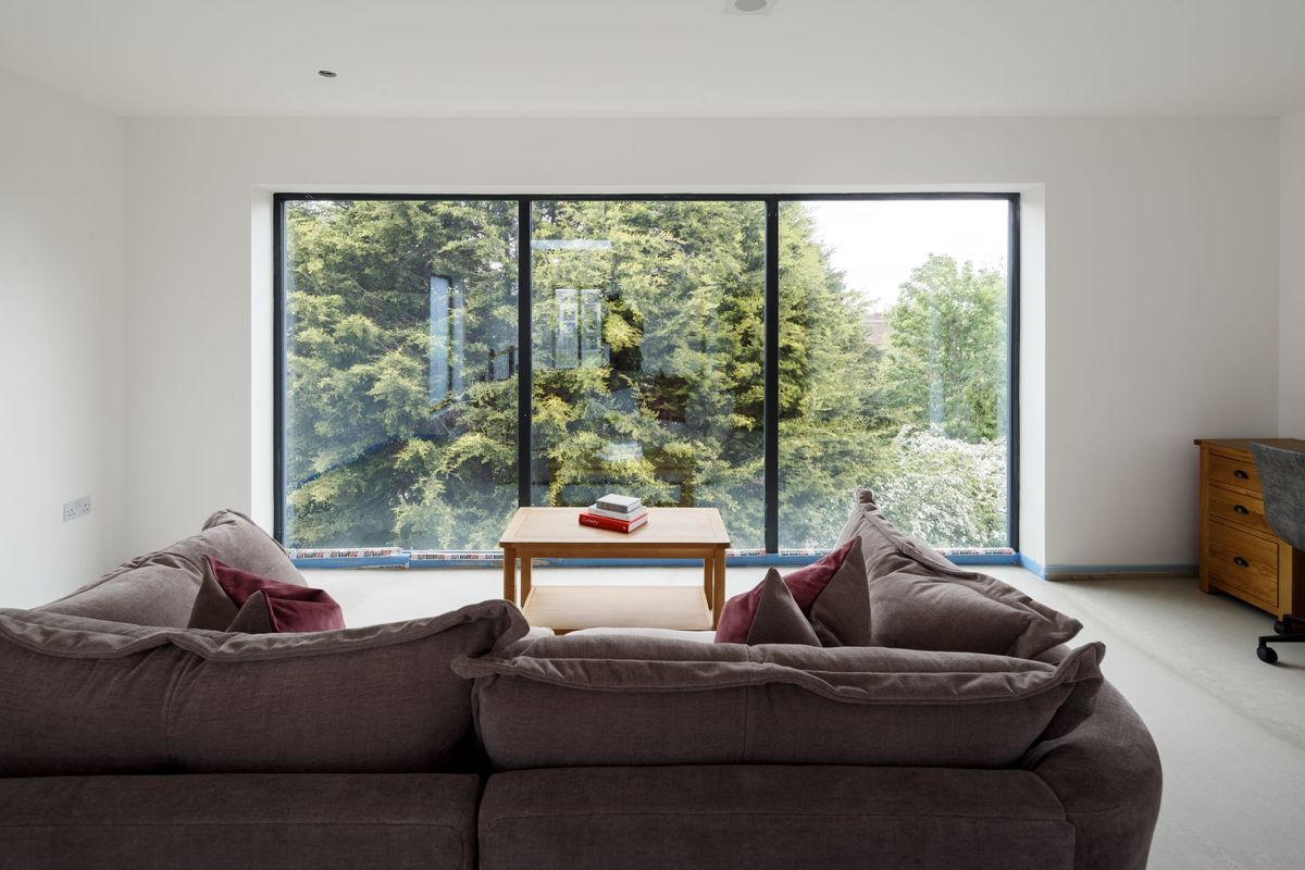 The sofa looks out of the window on the second floor of the home