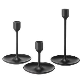 three black candlestick holders with round bases