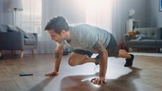 A man performing mountain climbers during a home workout