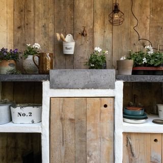 outdoor sink ideas: stone basin amongst pots and flowers