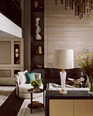 Neutral colored living room with large ceiling light and table lamp