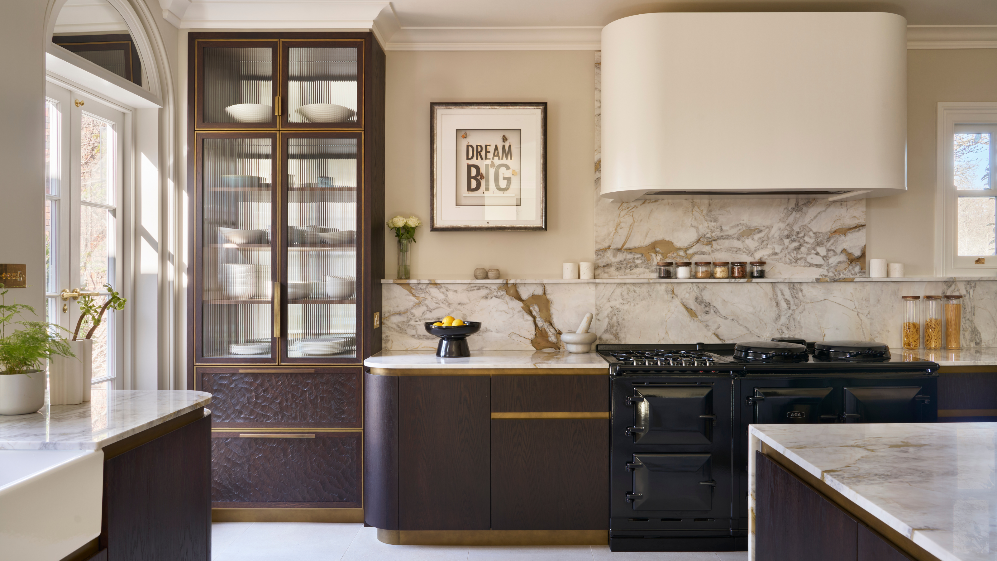 large modern kitchen with a range cooker, dark cabinets and soft, curved edges