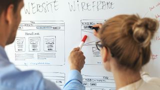 man and woman working on website design on whiteboard