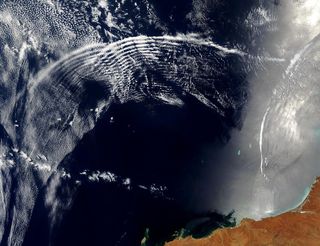 The pattern of atmospheric gravity waves is visible in this satellite image of double, overlapping arcs of clouds over the Indian Ocean.