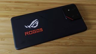 Asus ROG Phone 9 Pro with AniMe lighting at back illuminated with red words reading "ROG09" and white logo