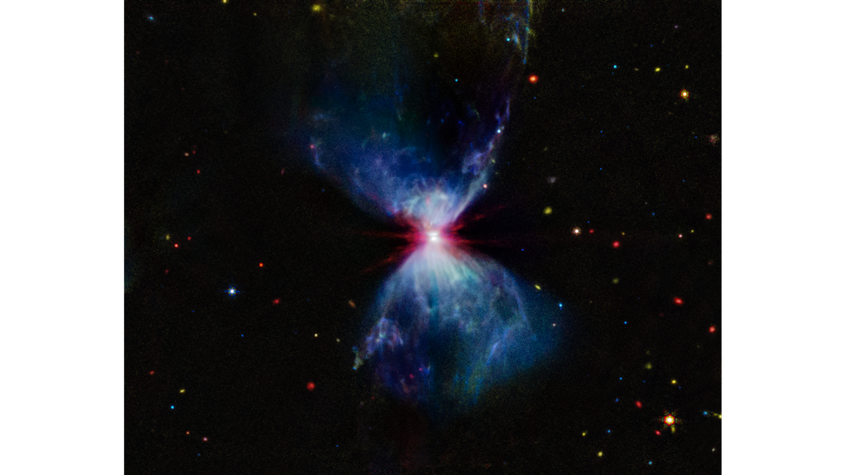 &quot;L1527, shown in this image from NASA’s James Webb Space Telescope’s MIRI (Mid-Infrared Instrument), is a molecular cloud that harbors a protostar. It resides about 460 light-years from Earth in the constellation Taurus. The more diffuse blue light and the filamentary structures in the image come from organic compounds known as polycyclic aromatic hydrocarbons (PAHs), while the red at the center of this image is an energized, thick layer of gases and dust that surrounds the protostar. The region in between, which shows up in white, is a mixture of PAHs, ionized gas, and other molecules. This image includes filters representing 7.7 microns light as blue, 12.8 microns light as green, and 18 microns light as red&quot;