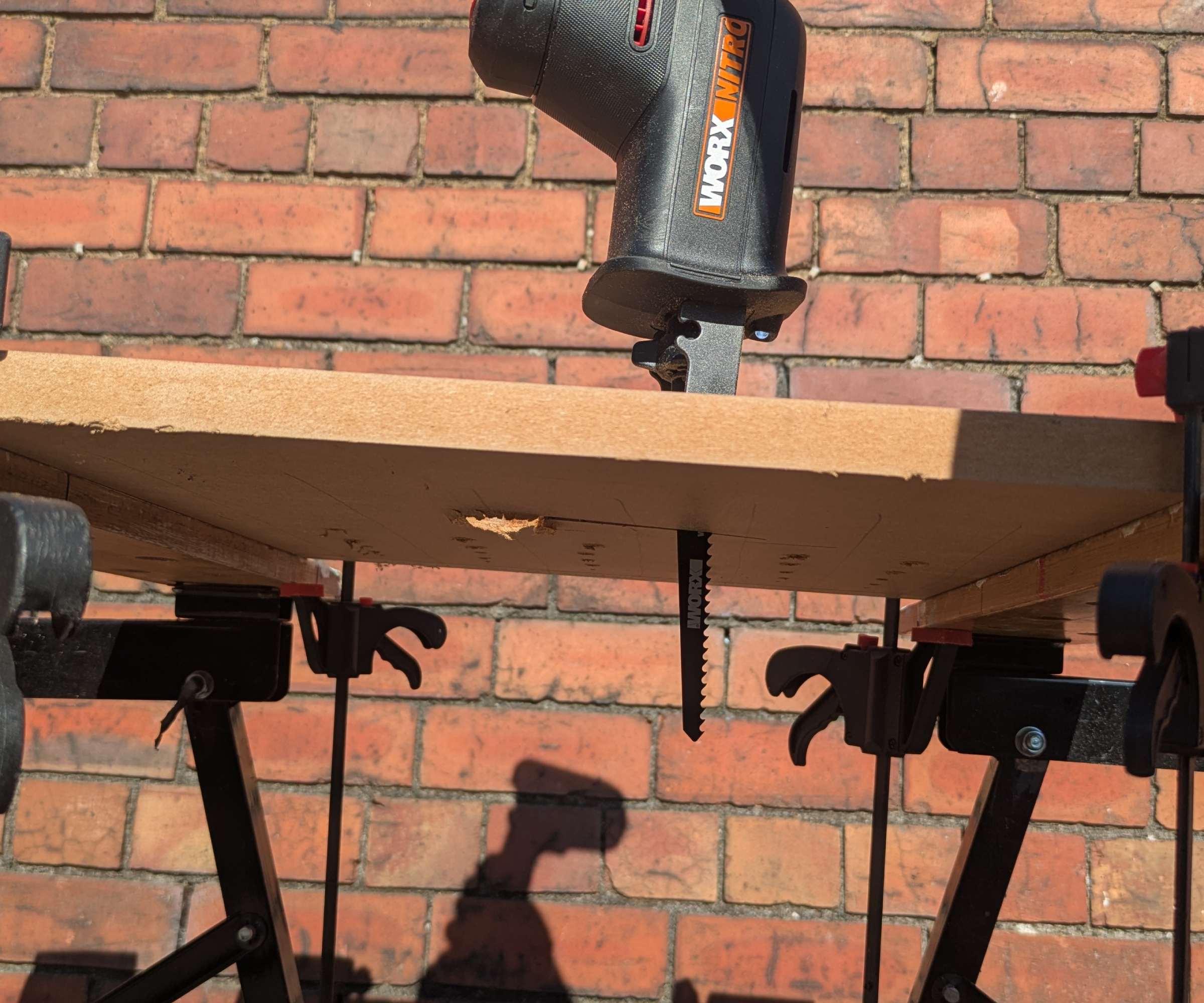 Reciprocating saw plunge-cutting into MDF from above
