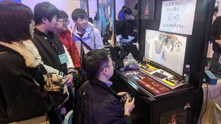A small group watches as one player struggles with an intense boss battle.