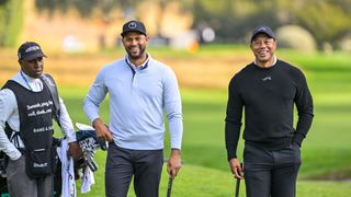 Tiger Woods shares a joke with Aaron Hicks at the pro-am for the Genesis Invitational