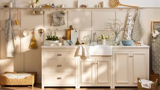 utility space with cream cabinets, wall panelling, shelving, dog bed and various kitchen related items
