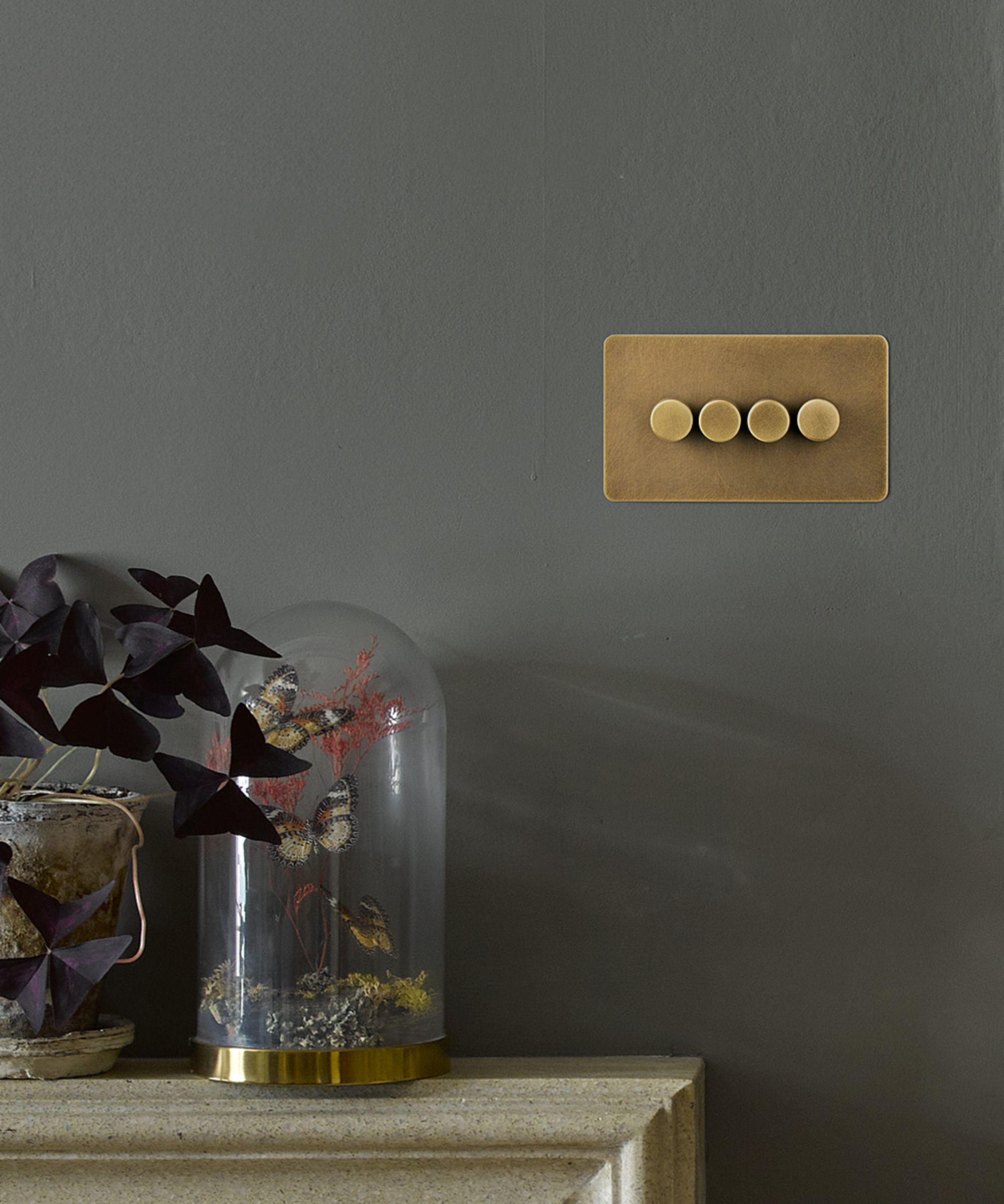 brass 4 gang dimmer switch on grey wall