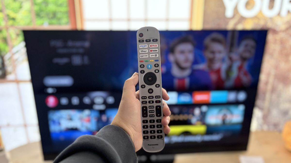 The Panasonic Z90B 48-inch OLED TV's remote control held in front of the TV.