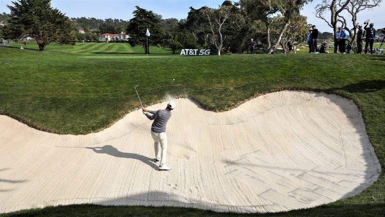 A golfer attempts an up and down in golf from a bunker