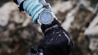 Polar Grit X: person holding bike while wearing the watch