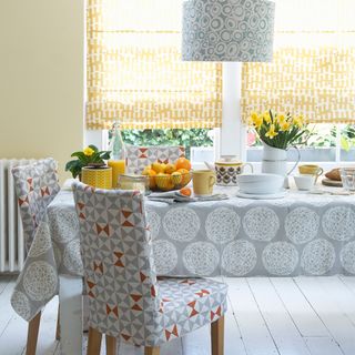 dining room with dining table and grey table cloth with flower jar