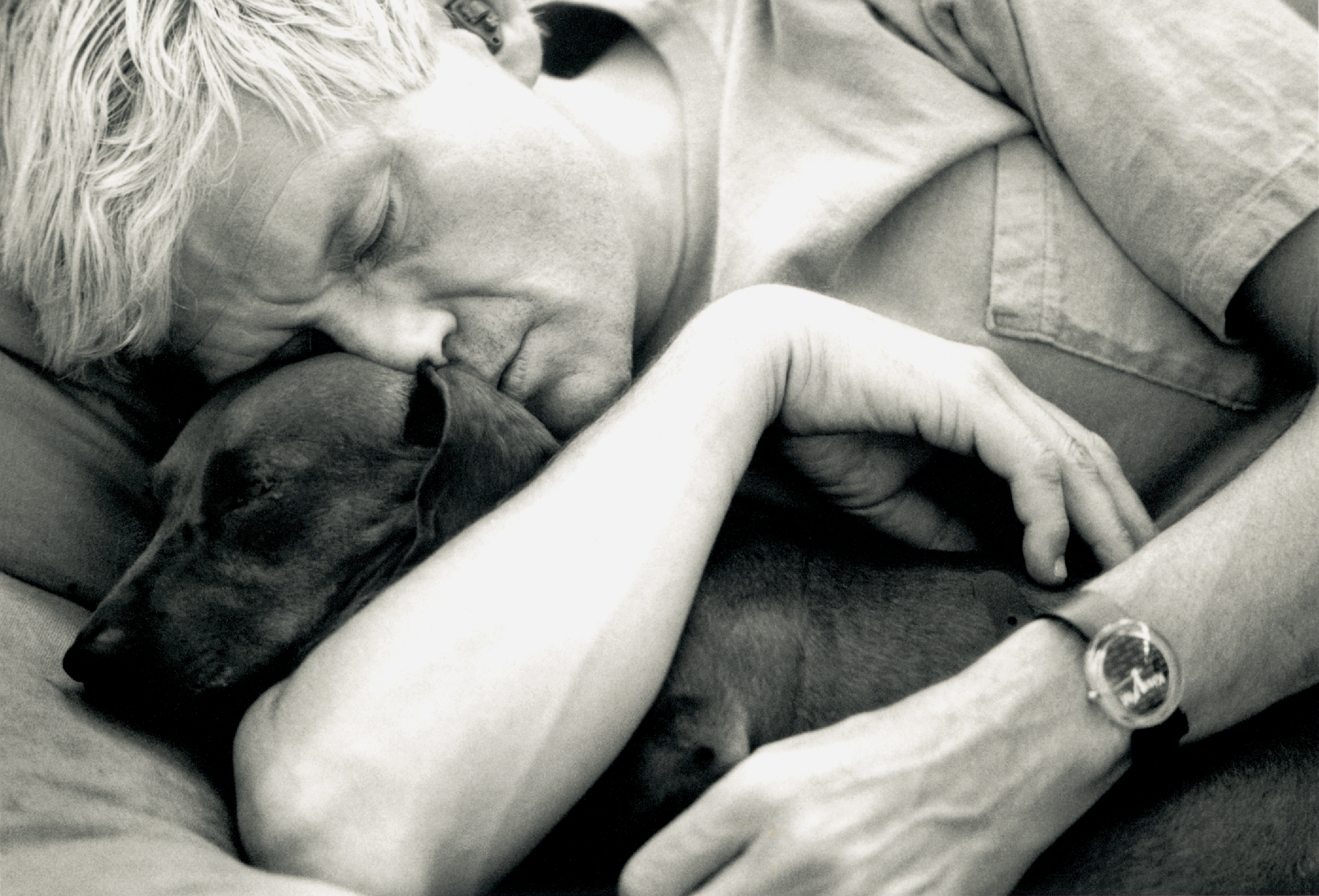 David Hockney cuddling one of his pet dogs.