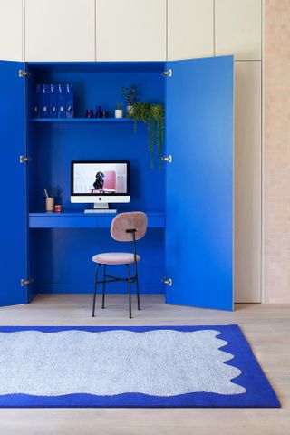 Pink closet with built in home office painted bold blue