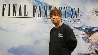 An image of Final Fantasy 16 producer Naoki Yoshida standing in front of a banner advertising the game.